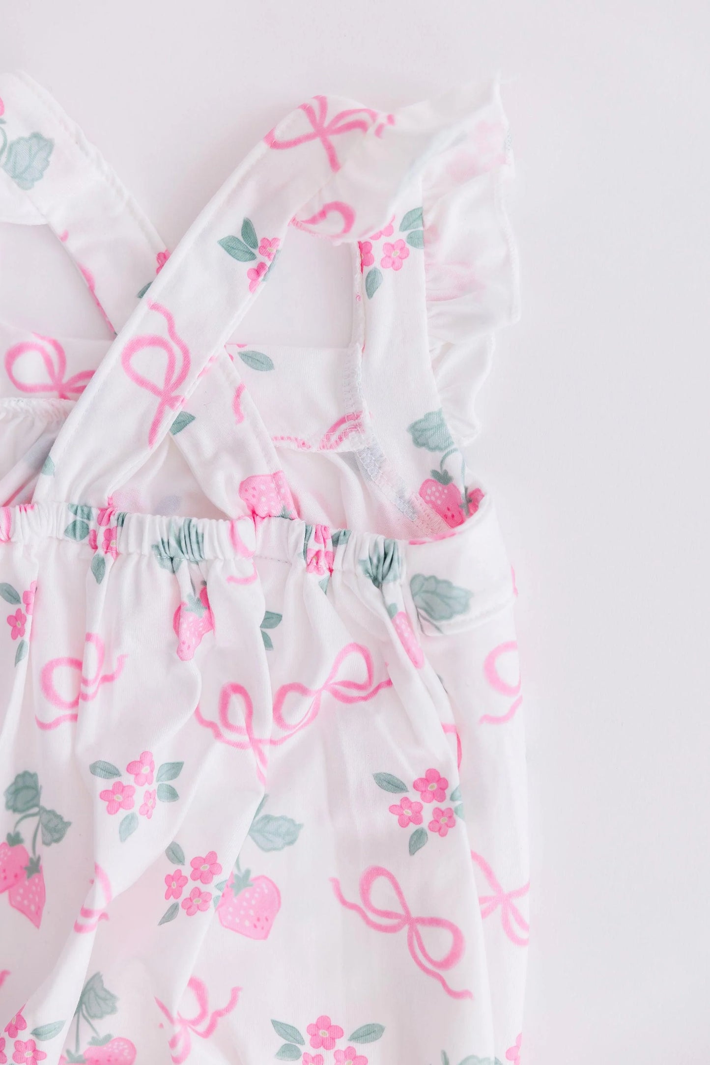 BERRIES & BOWS RUFFLE CROSS BACK ROMPER
